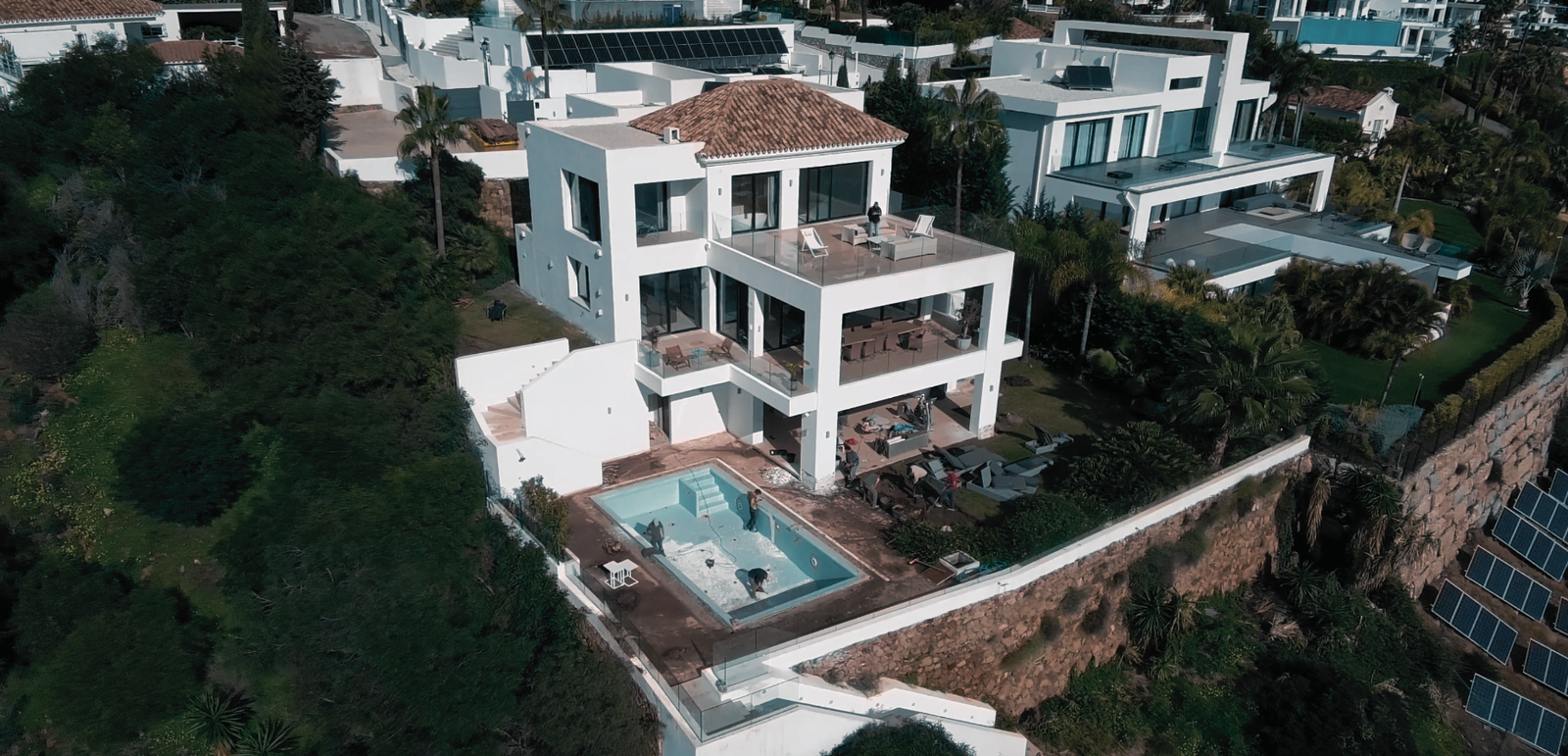 Vista aérea de una villa blanca con piscina sobre una ladera de la Costa del Sol